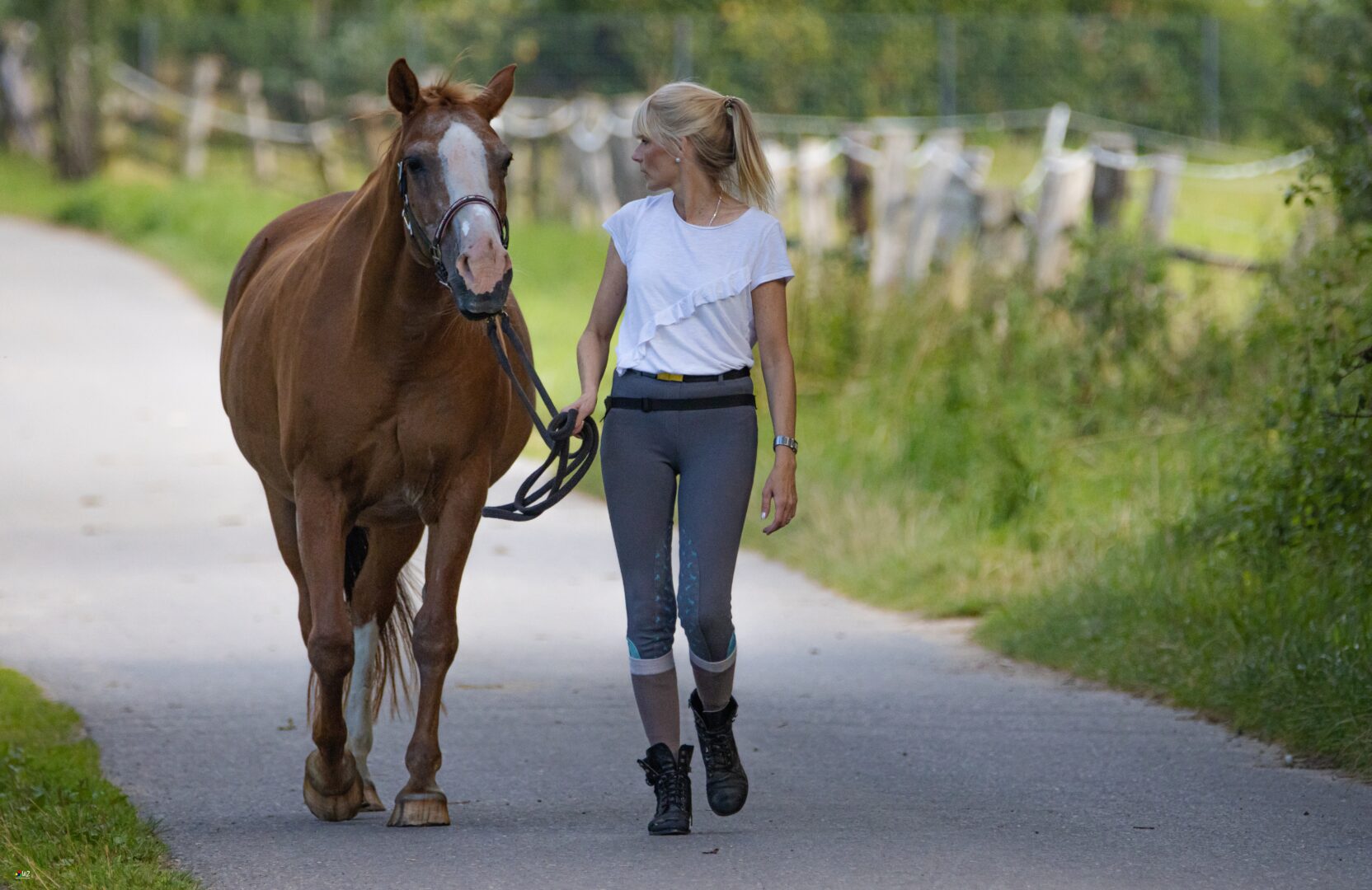 girl with white top walking with horse