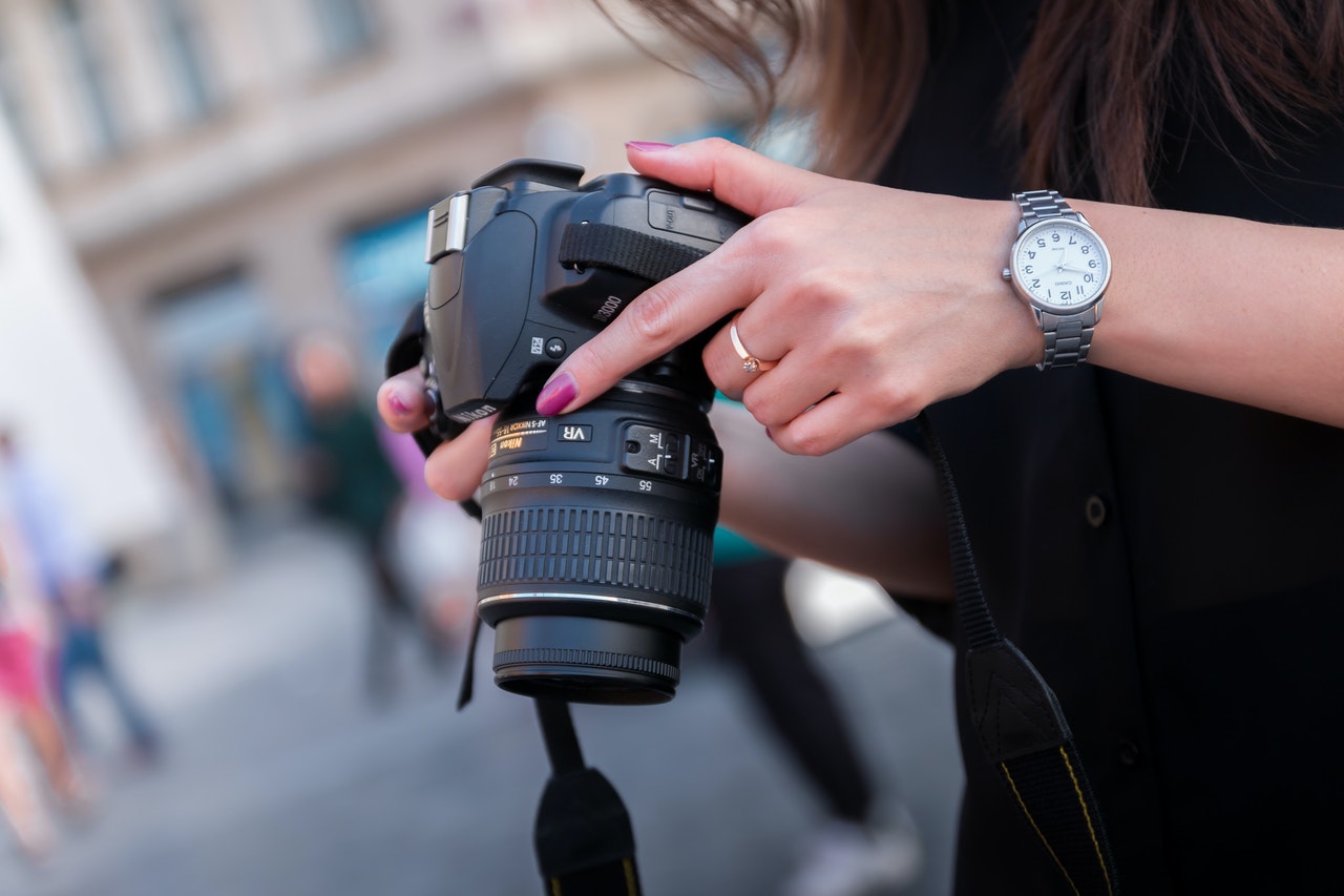 woman holding a black dslr camera