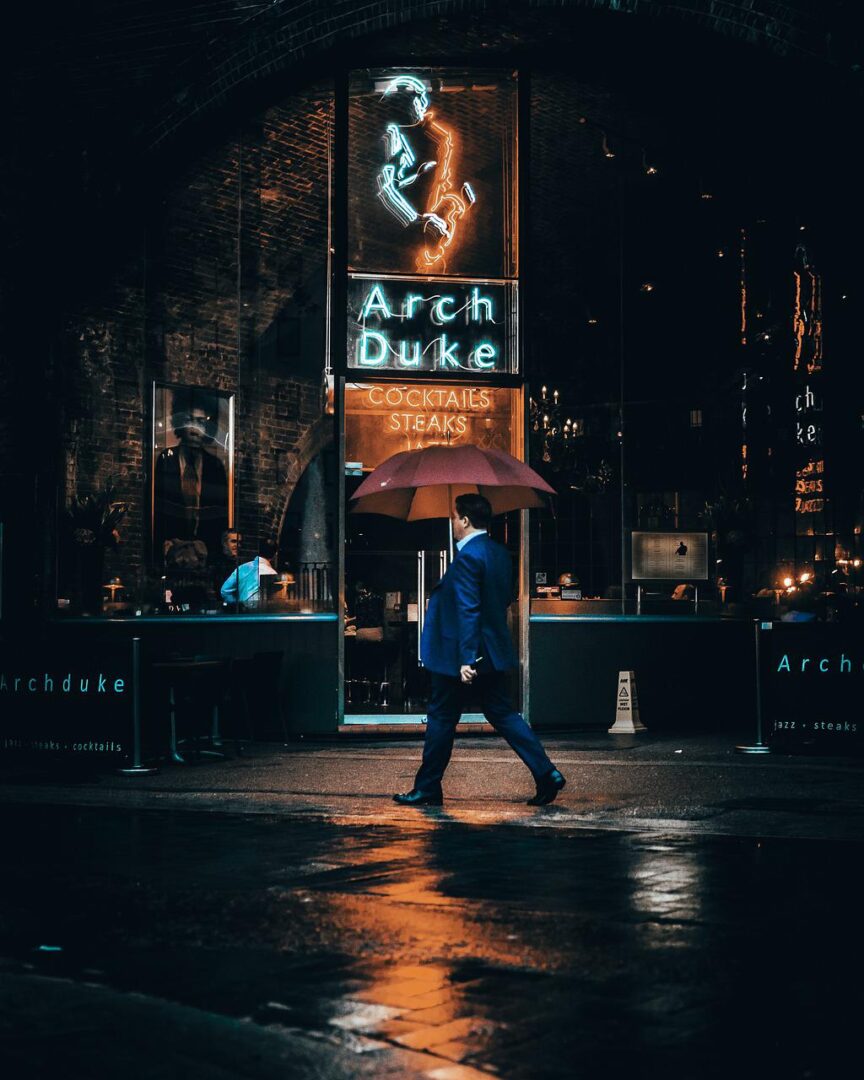 man walking with umbrella by Canon 1DX Mark II